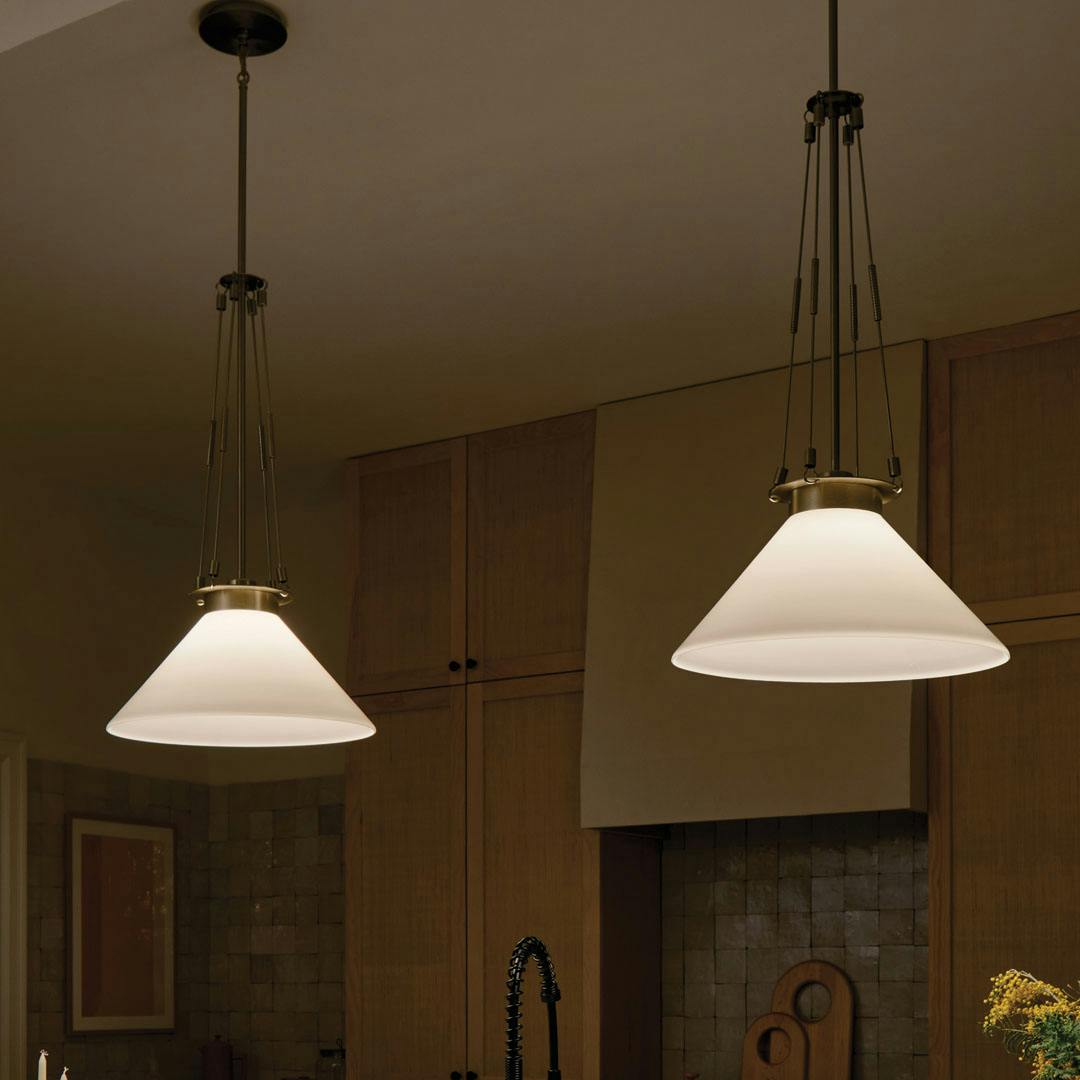 Night time kitchen with the Albers 18.25 Inch 1 Light Pendant with Opal Glass in Champagne Bronze