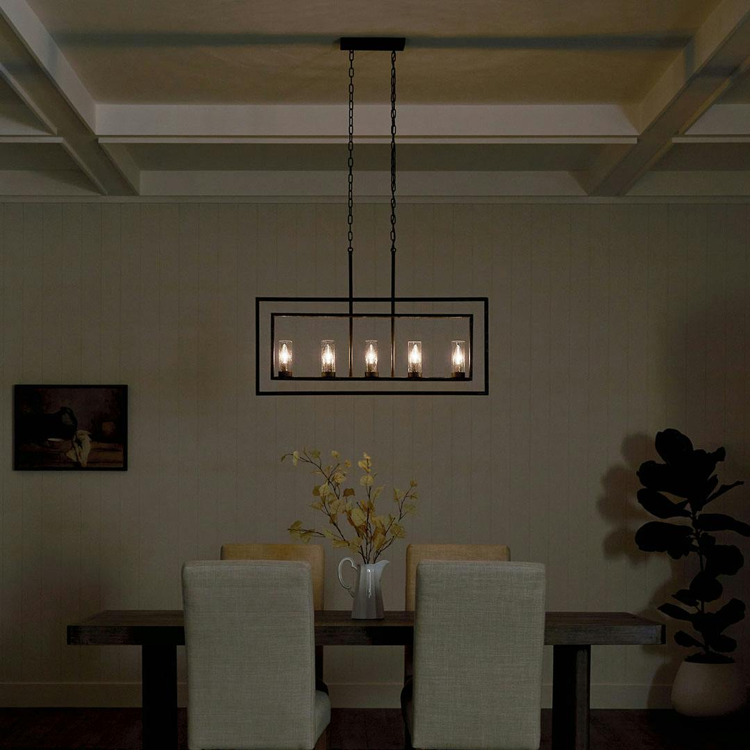 Dining roomat night with the Vervain 5 Light Linear Chandelier in Distressed Black