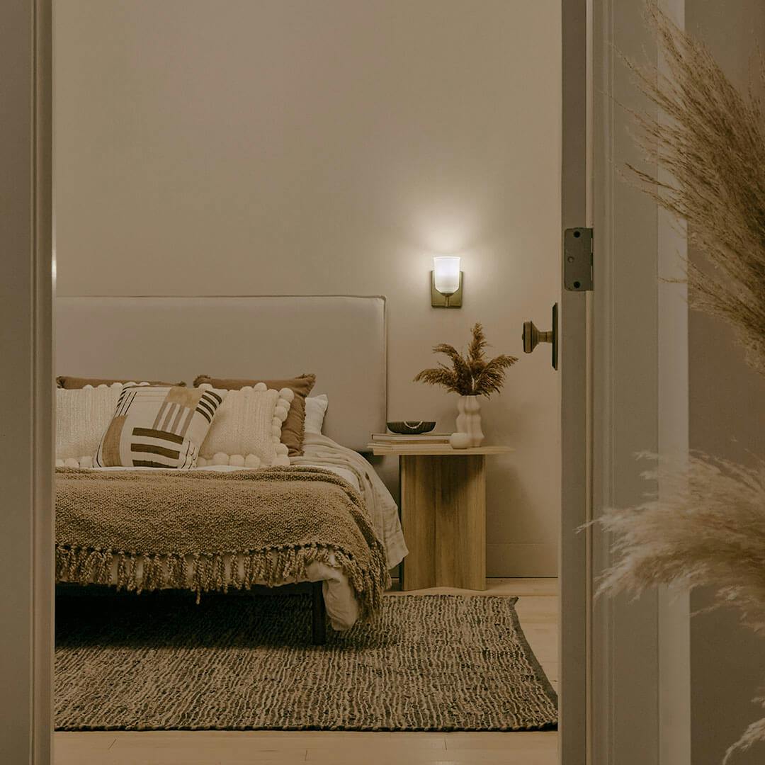 Bedroom at night with the Shailene 5" 1-Light Wall Sconce in Natural Brass