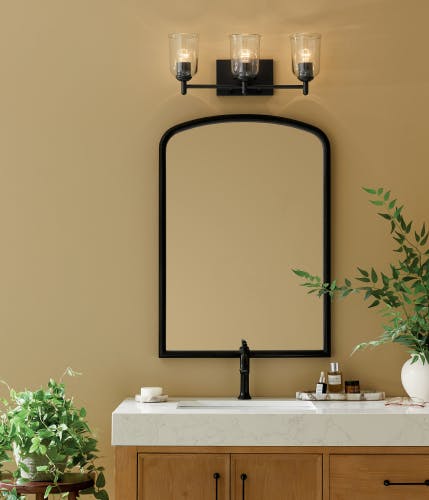A bathroom lit with Shailene vanity light above a bathroom sink during the day 