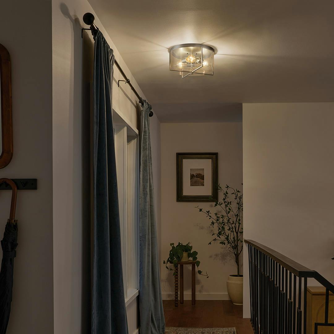 Night time hallway featuring the Birk 3 Light Flush Mount Light in Brushed Nickel