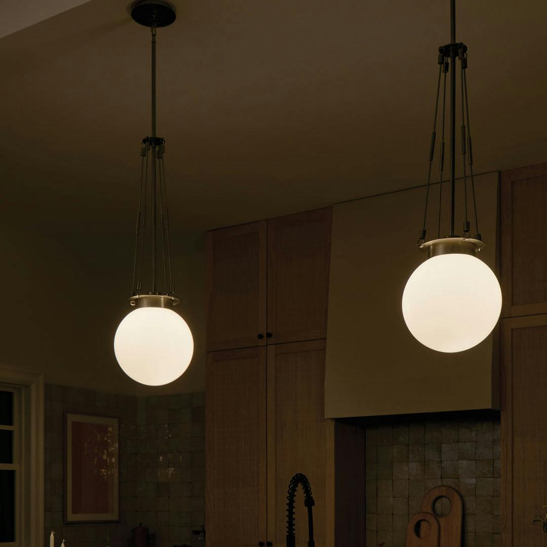 Night time kitchen with the Albers 10.5 Inch 1 Light Pendant with Opal Glass in Champagne Bronze