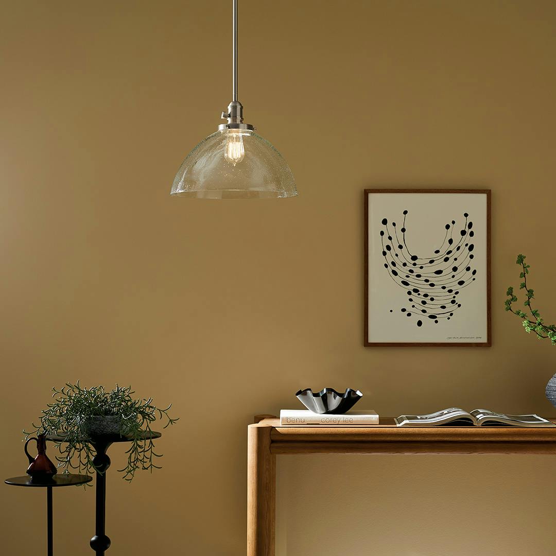 The Avery 11" 1-Light Dome Pendant with Clear Seeded Glass in Nickel hung by console table
