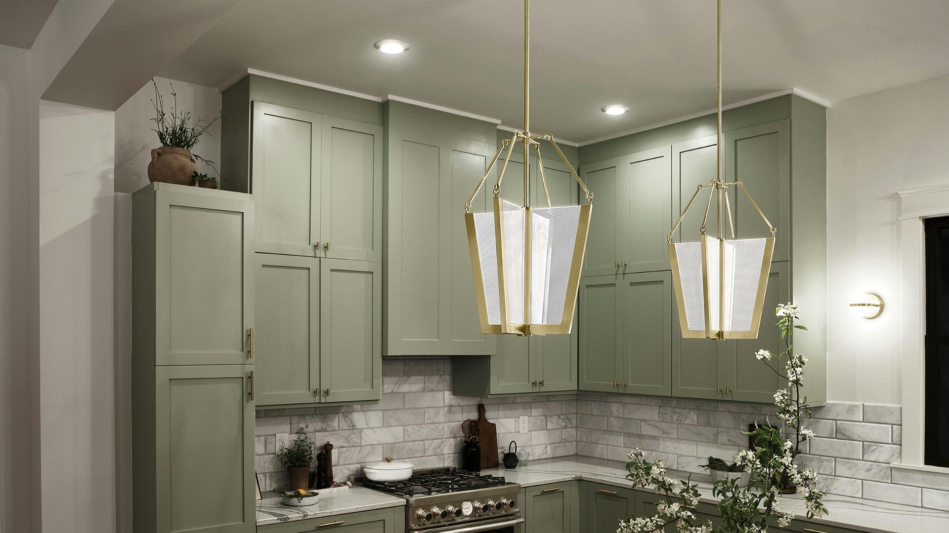 Bright, fresh kitchen with sage green cabinets and Carter's pendants over the counter