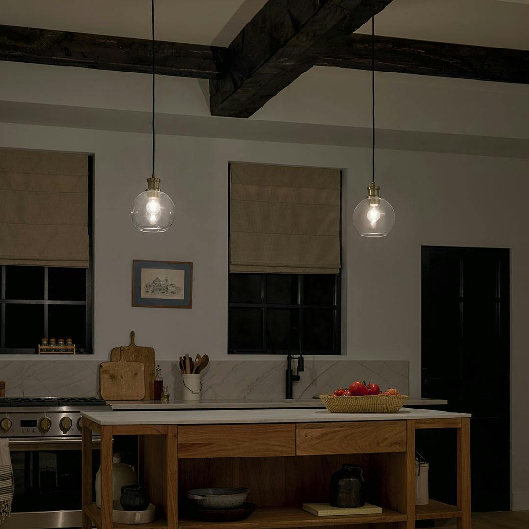 Kitchen at night with the Clove 1 Light Mini Pendant in Black and Brushed Natural Brass