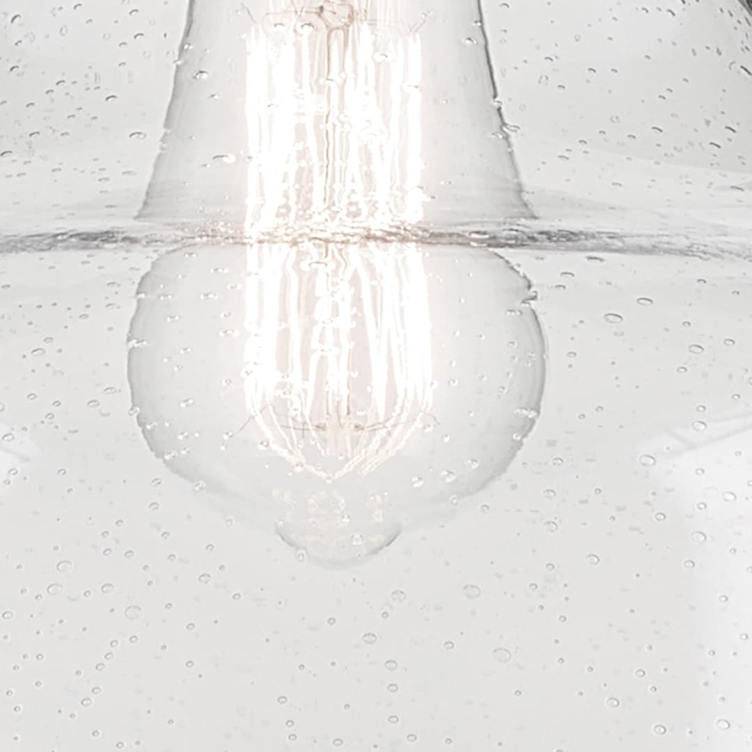 Close up view of the Avery 11.25" 1-Light Bell Pendant with Clear Seeded Glass in Natural Brass on a white background