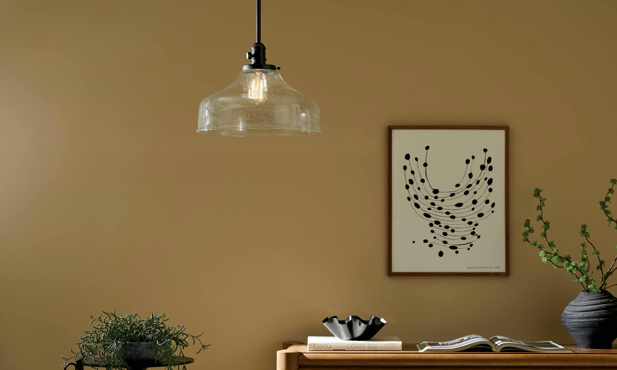 Lifestyle image of an office with an Avery pendant light above a desk turned on during the day 