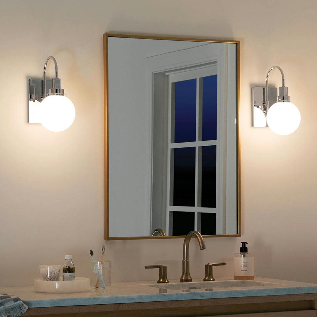 Bathroom at night with the Hex 11.5 Inch 1 Light Wall Sconce with Opal Glass in Chrome