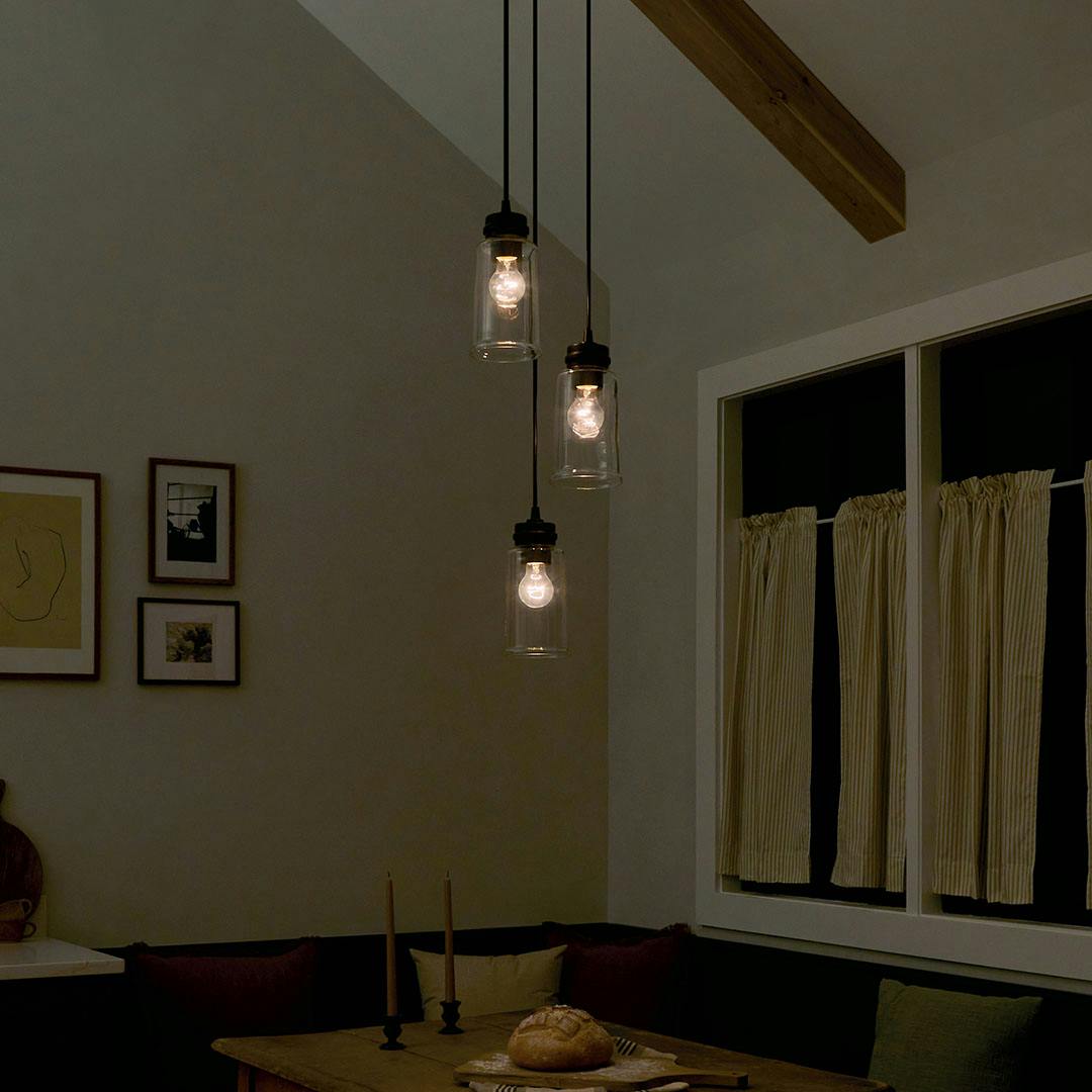 Dining room at night with the Jaylen 3 Light Cluster Pendant in Black