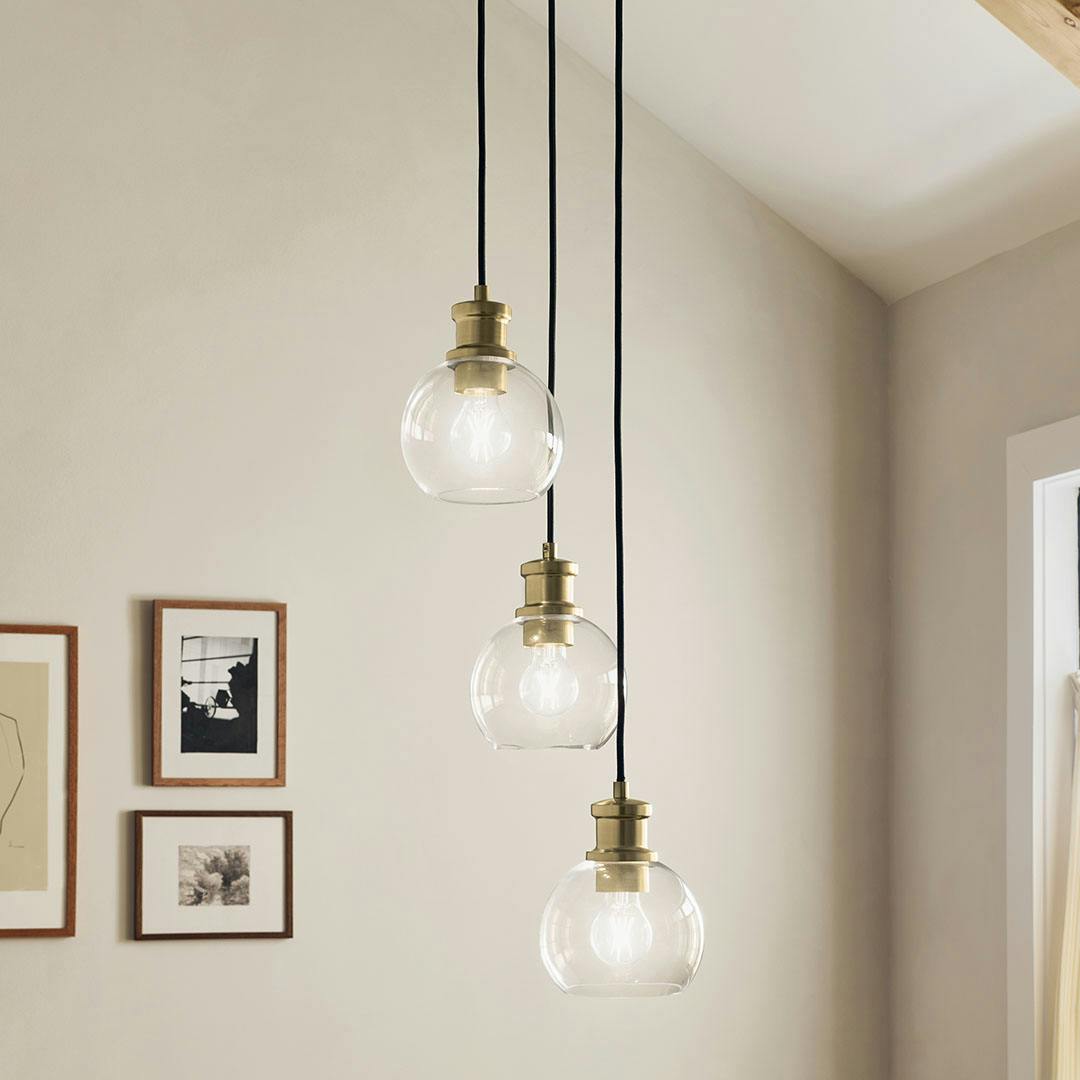 Dining room in day light with the Clove 3 Light Cluster Pendant in Black and Brushed Natural Brass