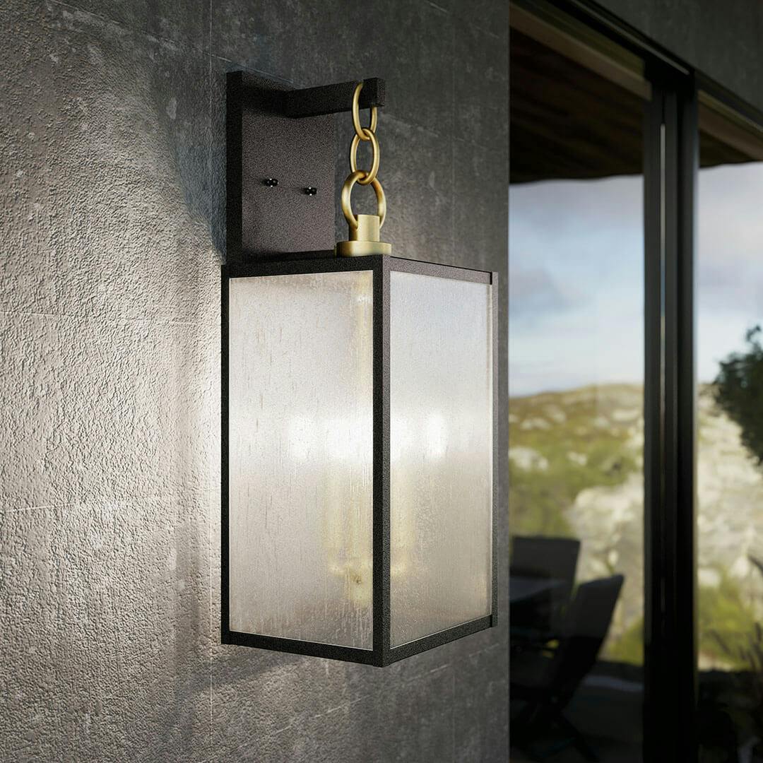 Patio in day light with the Lahden 26" 3 Light Outdoor Wall Light with Clear Seeded Glass in Weathered Zinc