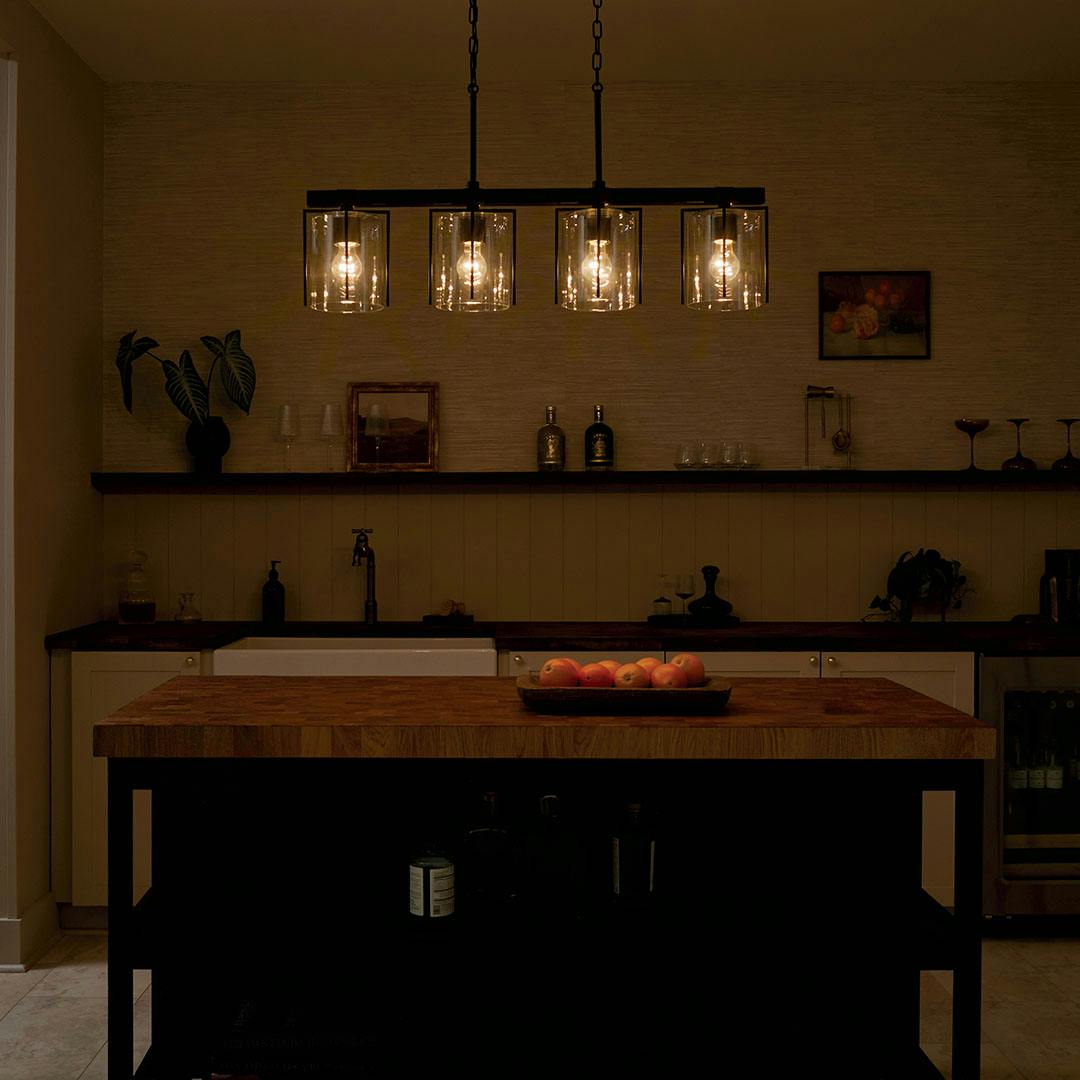 Home bar at night with the Birk 4 Light Linear Chandelier in Black