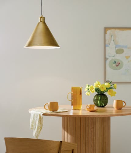 Dinning nook lit with a Zailey pendant above a wooden nook table 
