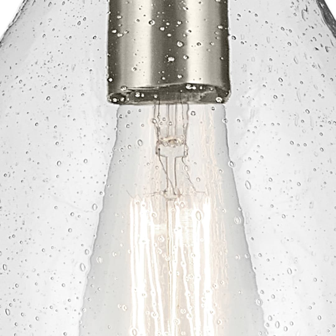 Close up view of the Everly 13.75" 1-Light Bell Pendant with Clear Seeded Glass in Brushed Nickel on a white background