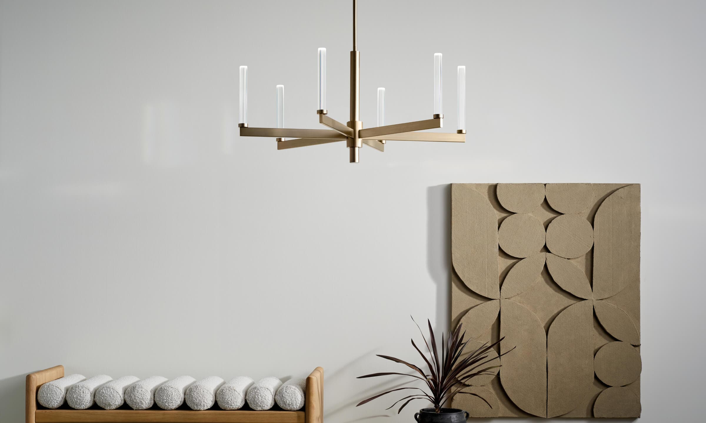 A detail shot of the Sycara 6 light chandelier with a Champagne Bronze finish turned on during the day 