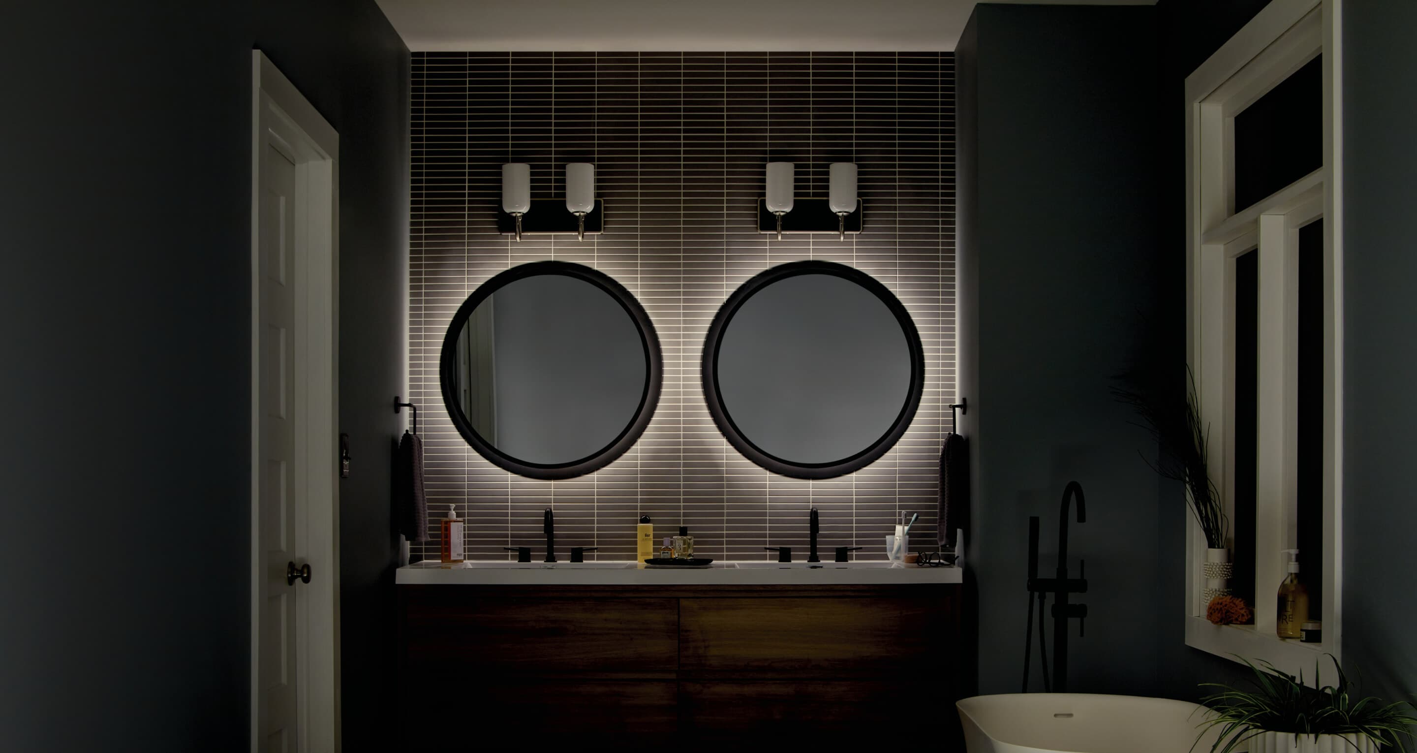 Bathroom with two Chennai mirrors above two sinks turned on at night